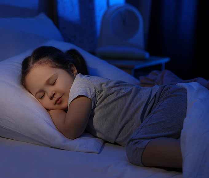 a young girl sleeping peacefully in a dark room 